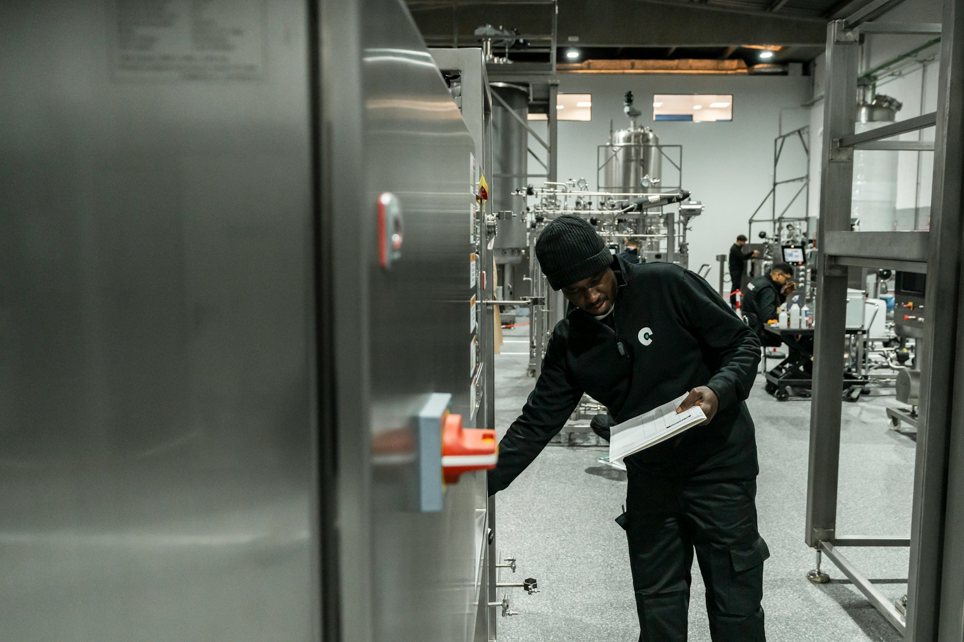 Worker checking equipment controls with an audit checklist