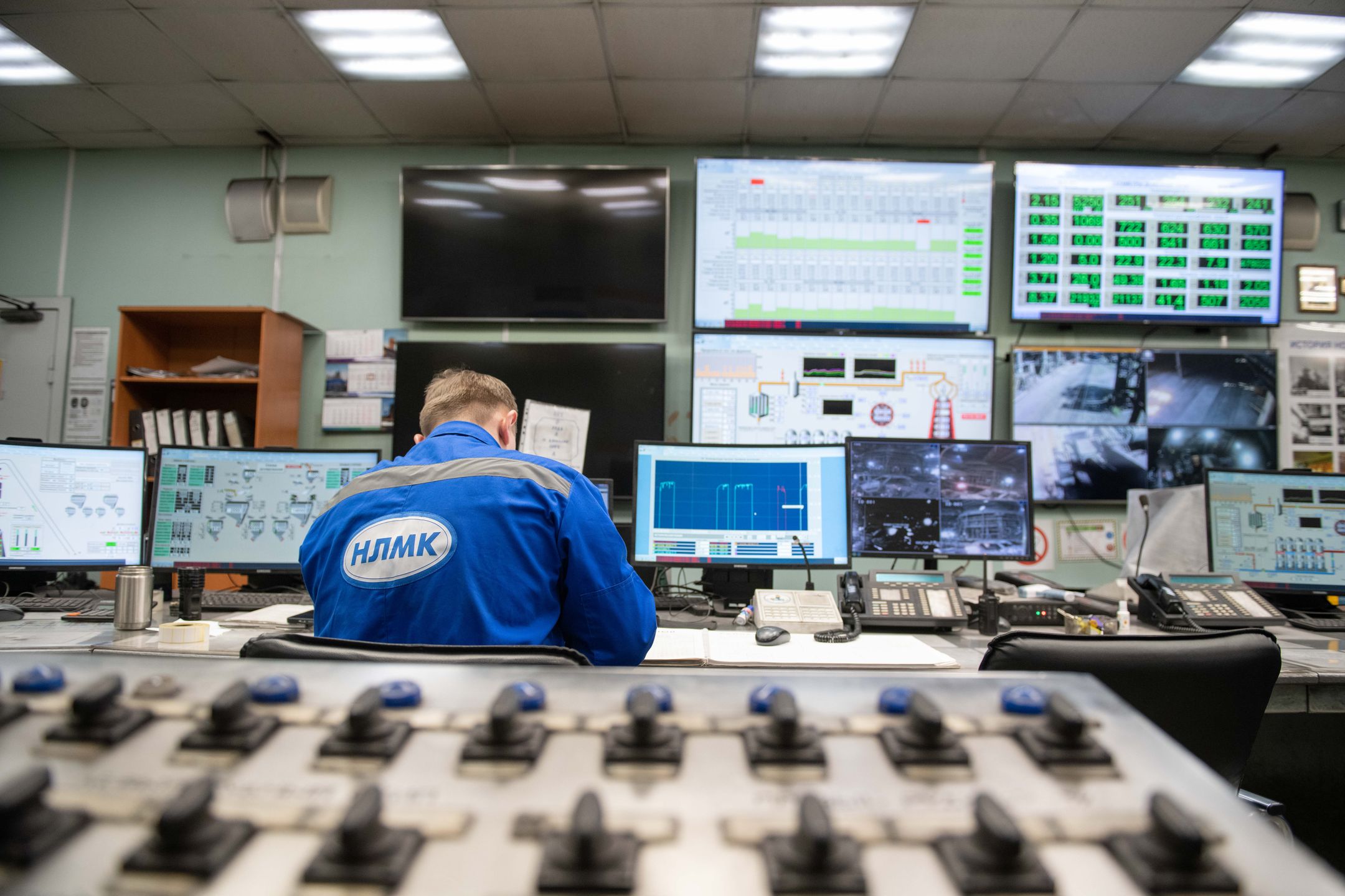 Engineer monitoring multiple screens in an industrial control room