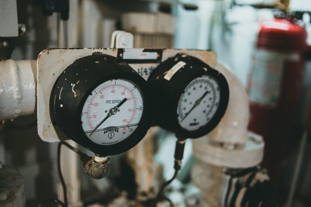 Technician adjusting a gas regulator with pressure gauges