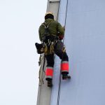 Worker wearing a safety harness while working at height