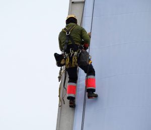 Worker wearing a safety harness while working at height