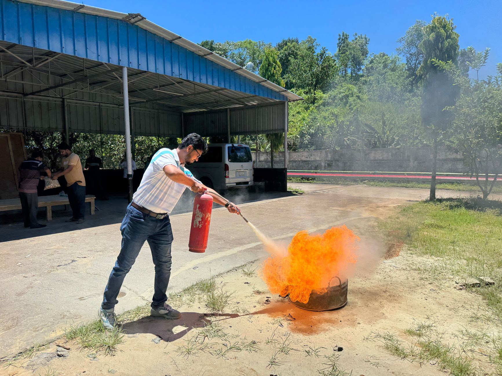 Instructor demonstrating fire extinguisher technique to employees