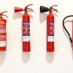Close-up of a red fire extinguisher canister