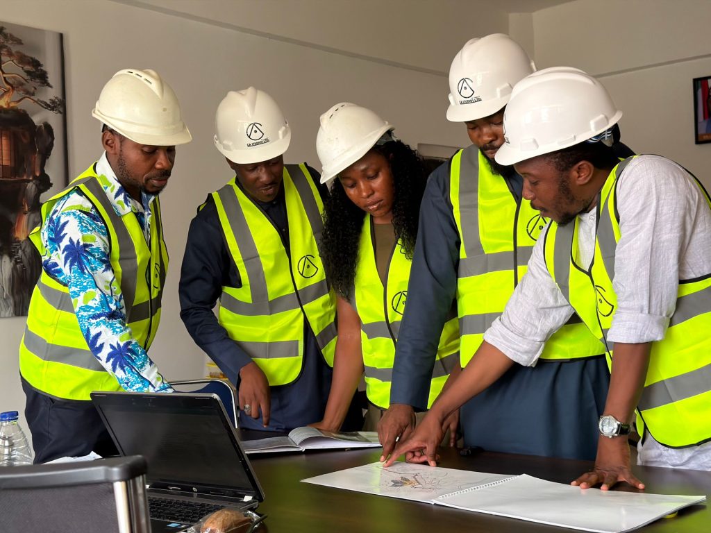 Engineers in safety gear reviewing blueprints