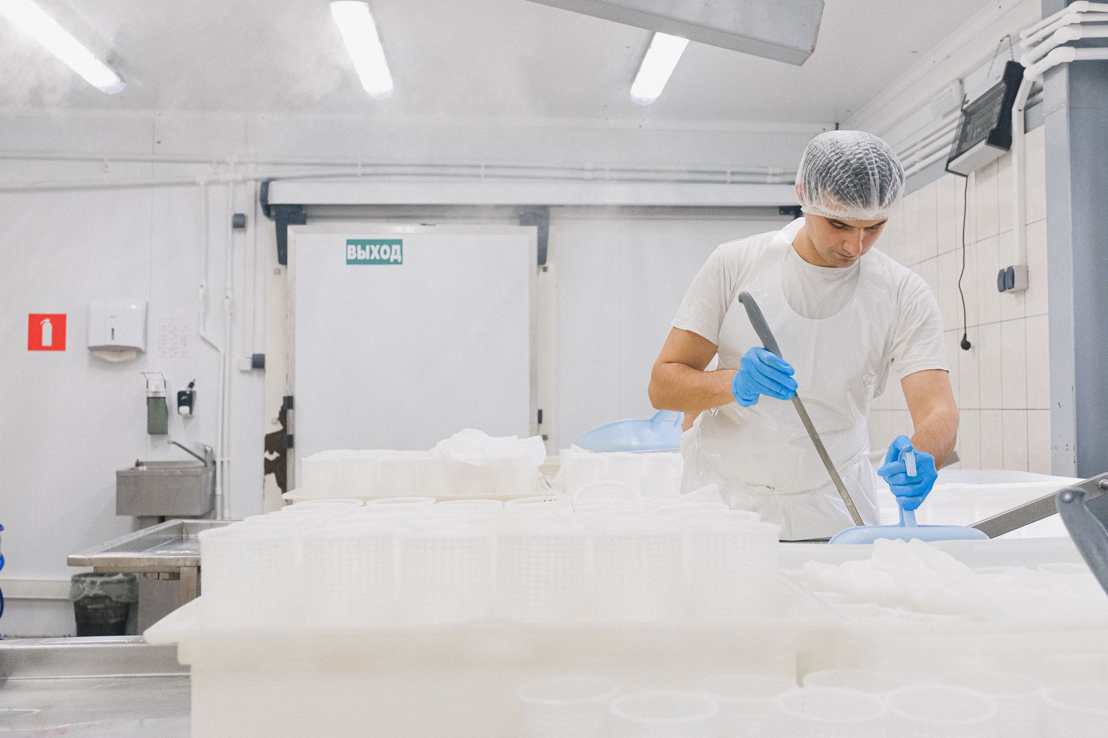 Worker in a food production facility following GMP protocols