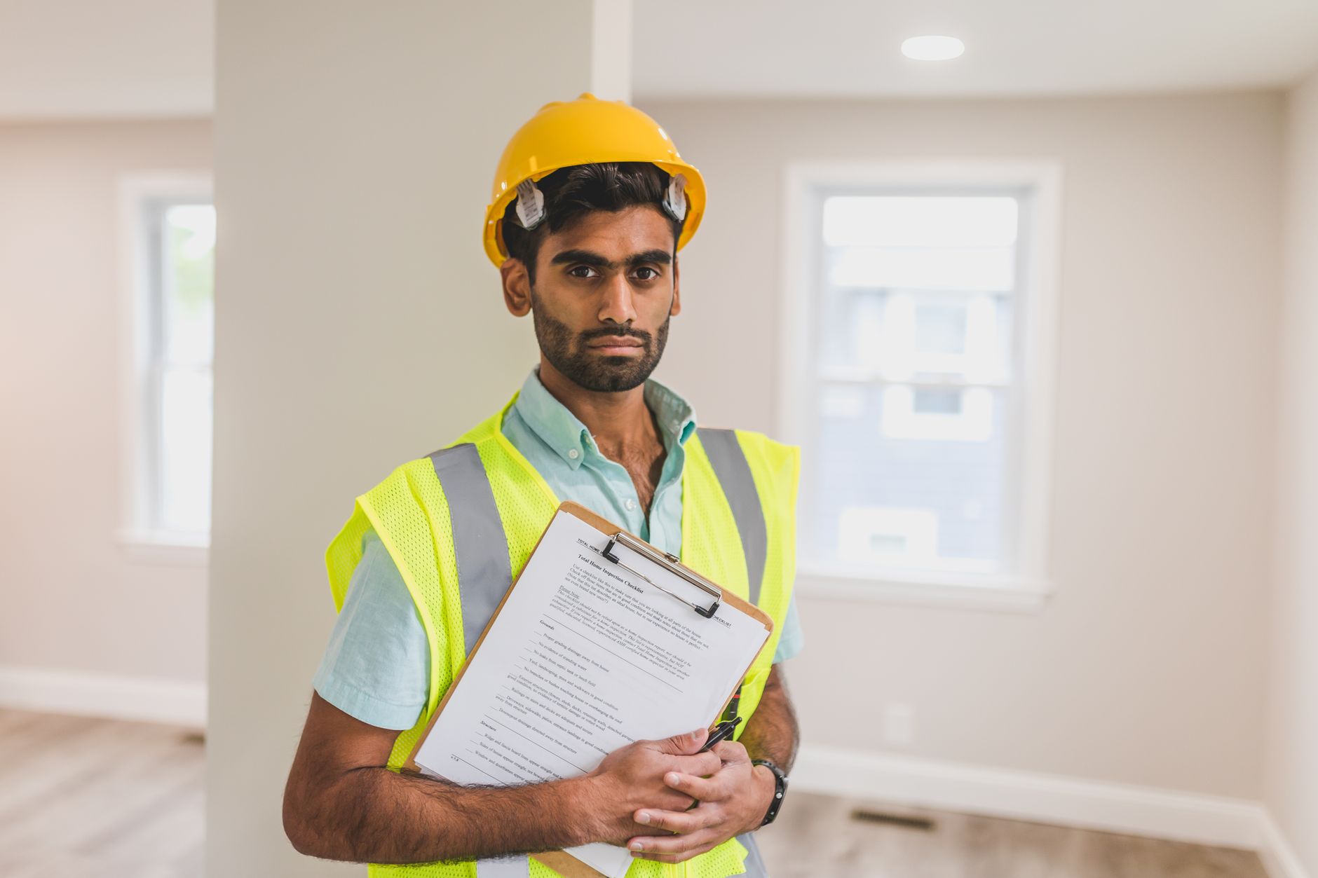 Inspector with a hard hat and clipboard conducting a facility inspection