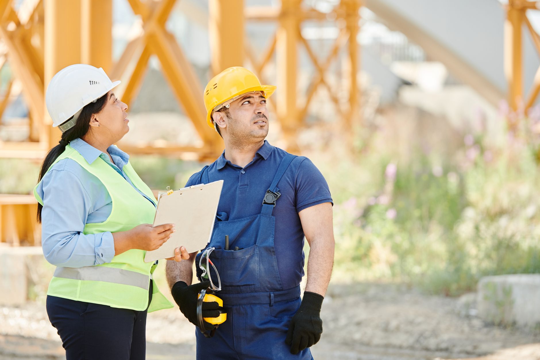 Supervisor fitting a worker with hearing protection