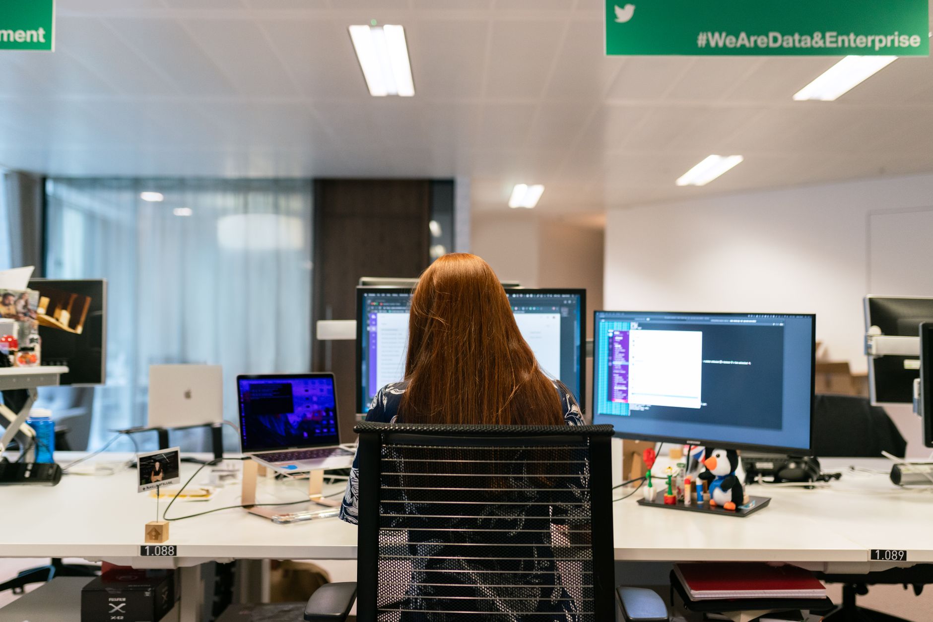 Engineer comparing PLC code across two monitors