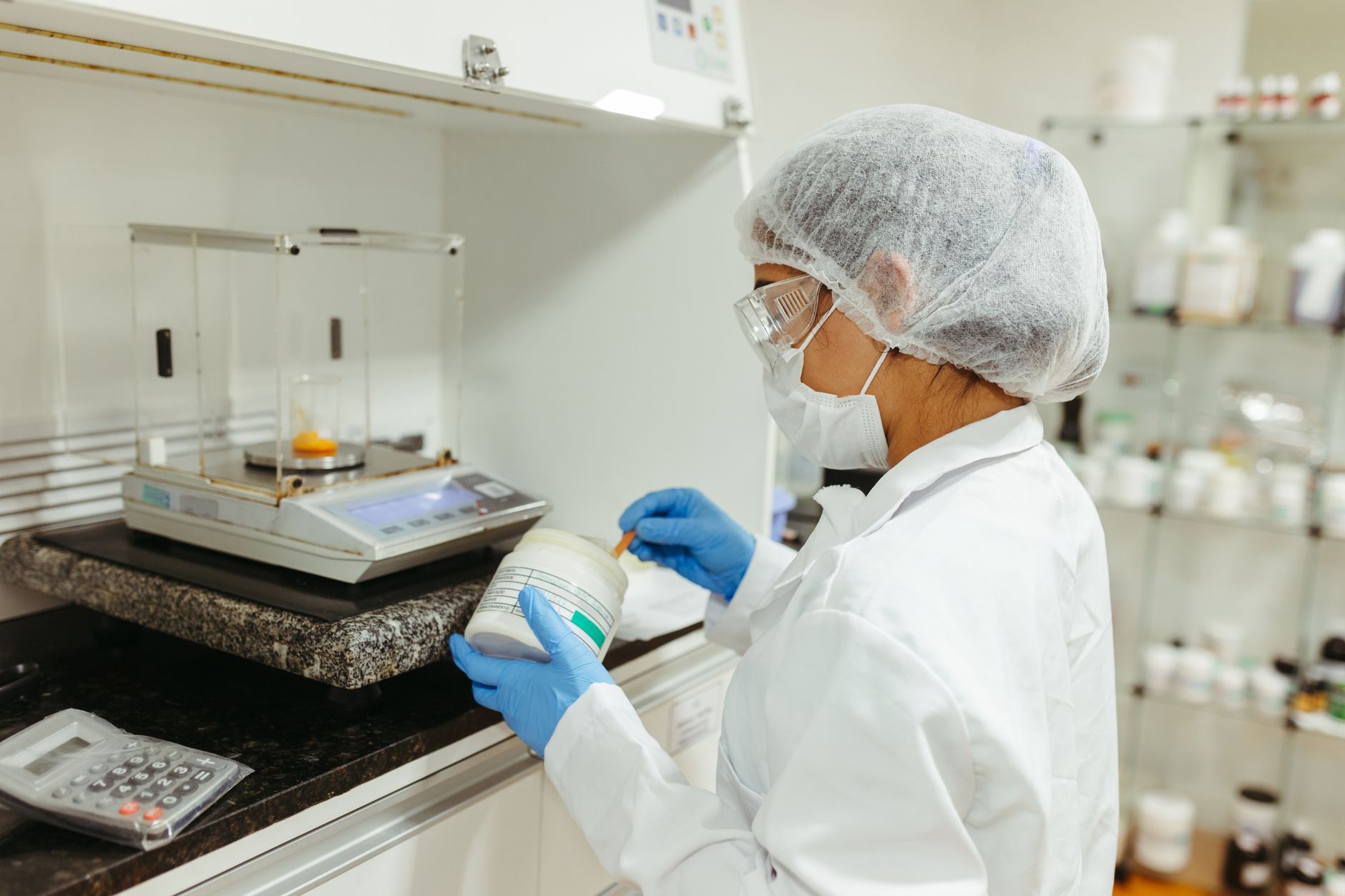 Technician calibrating a scale with reference weights