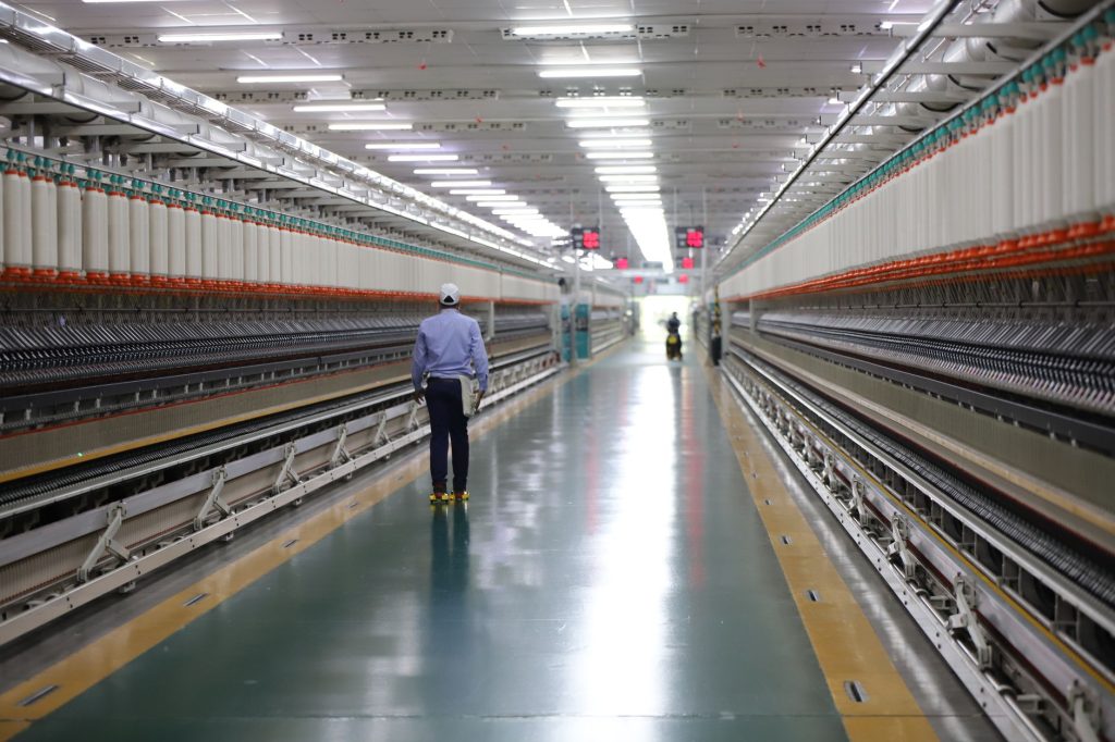Auditor walking a factory floor with a clipboard