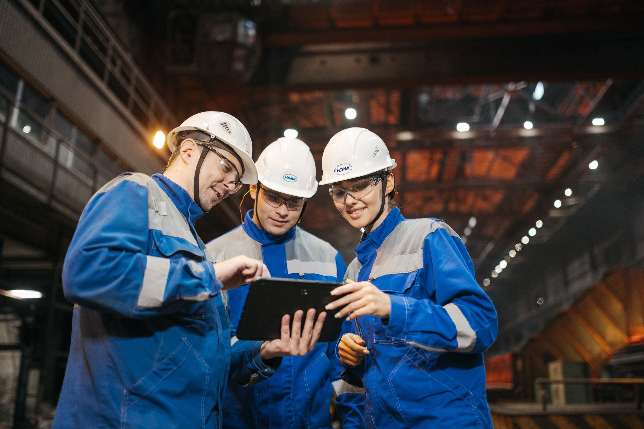 Team reviewing a plan on a tablet in an industrial facility