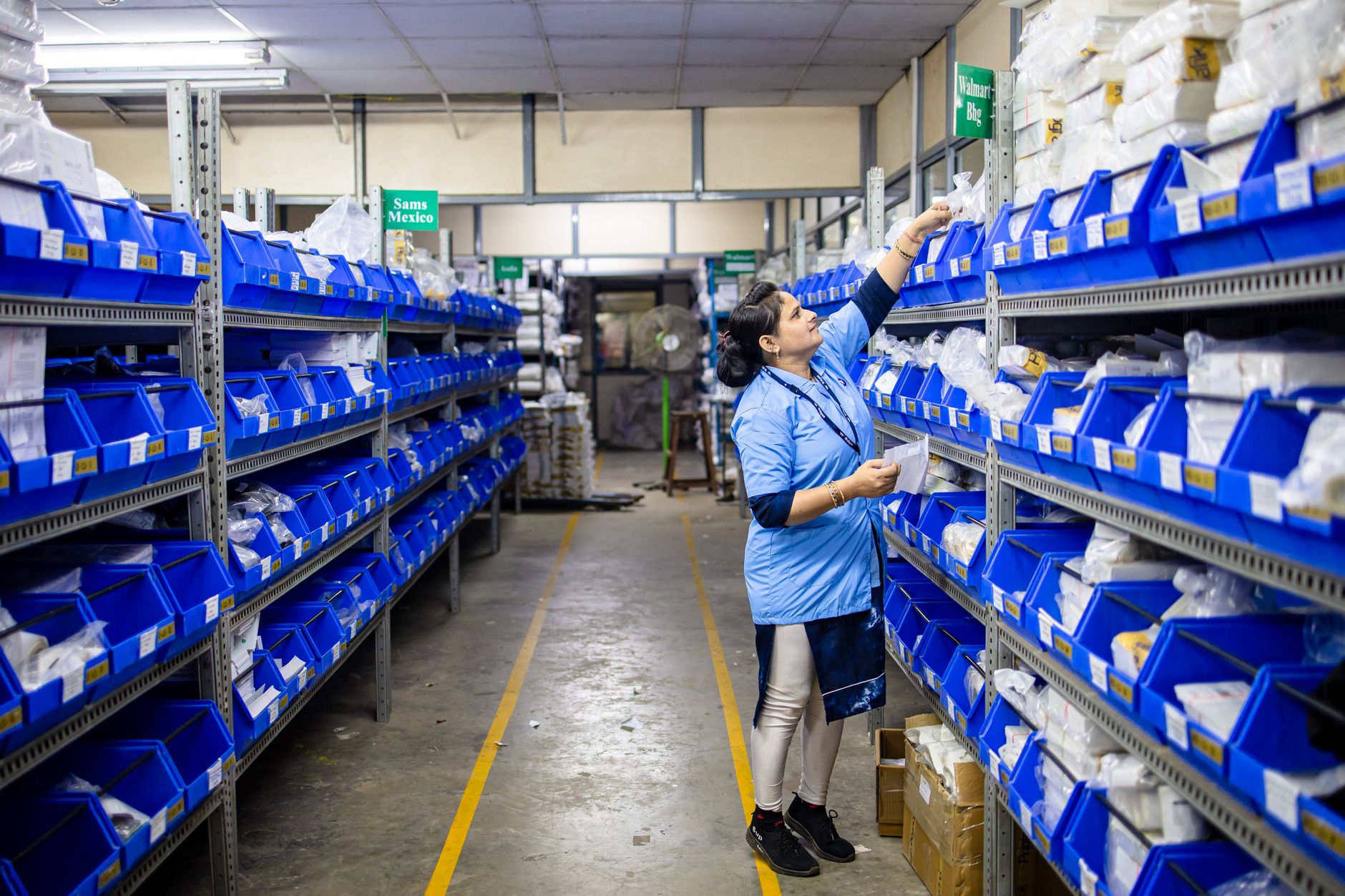 Warehouse worker replenishing a kanban bin