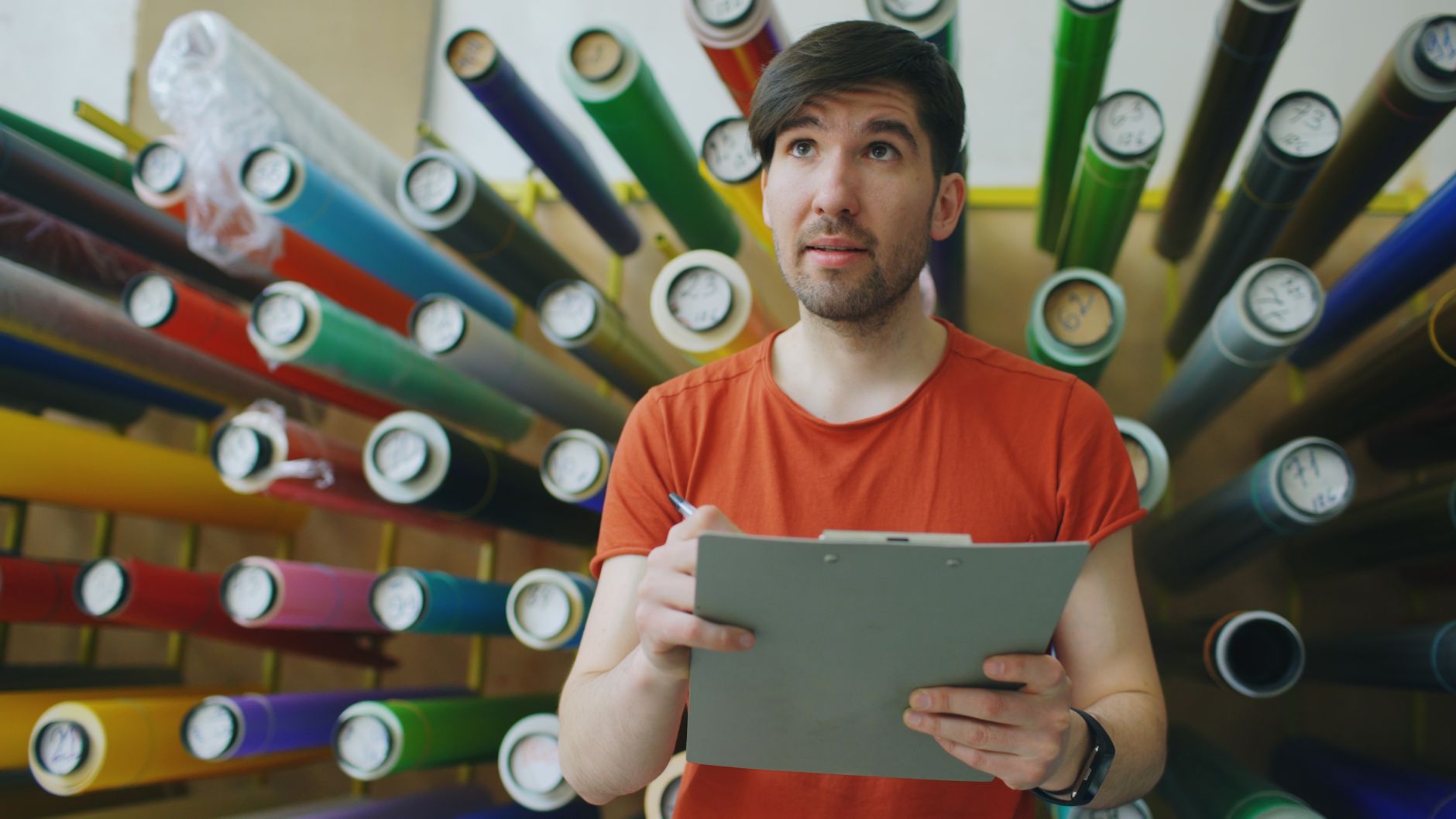Worker holding a clipboard in a materials workshop