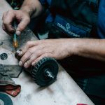 Technician using a grease gun on industrial equipment