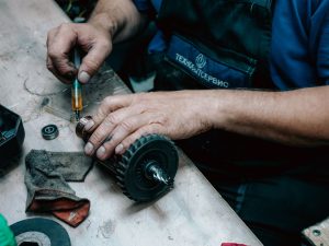 Technician using a grease gun on industrial equipment