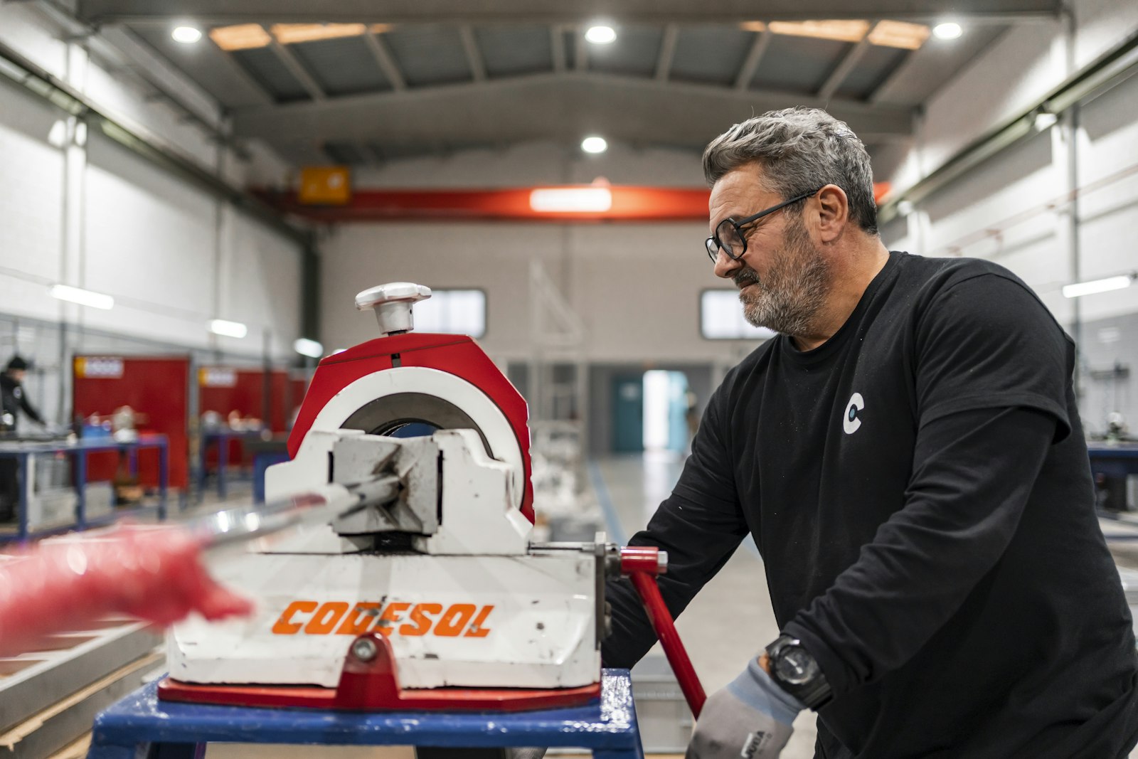 Machine shop operator running a tube-bending machine on the shop floor