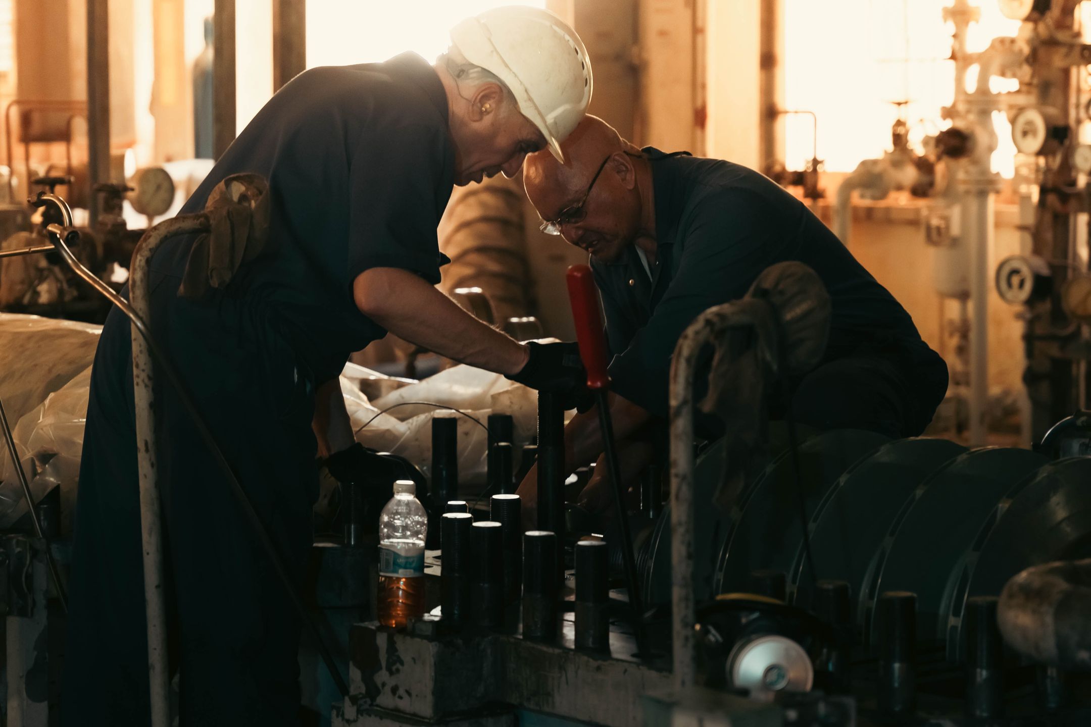Two engineers collaborating on machinery maintenance