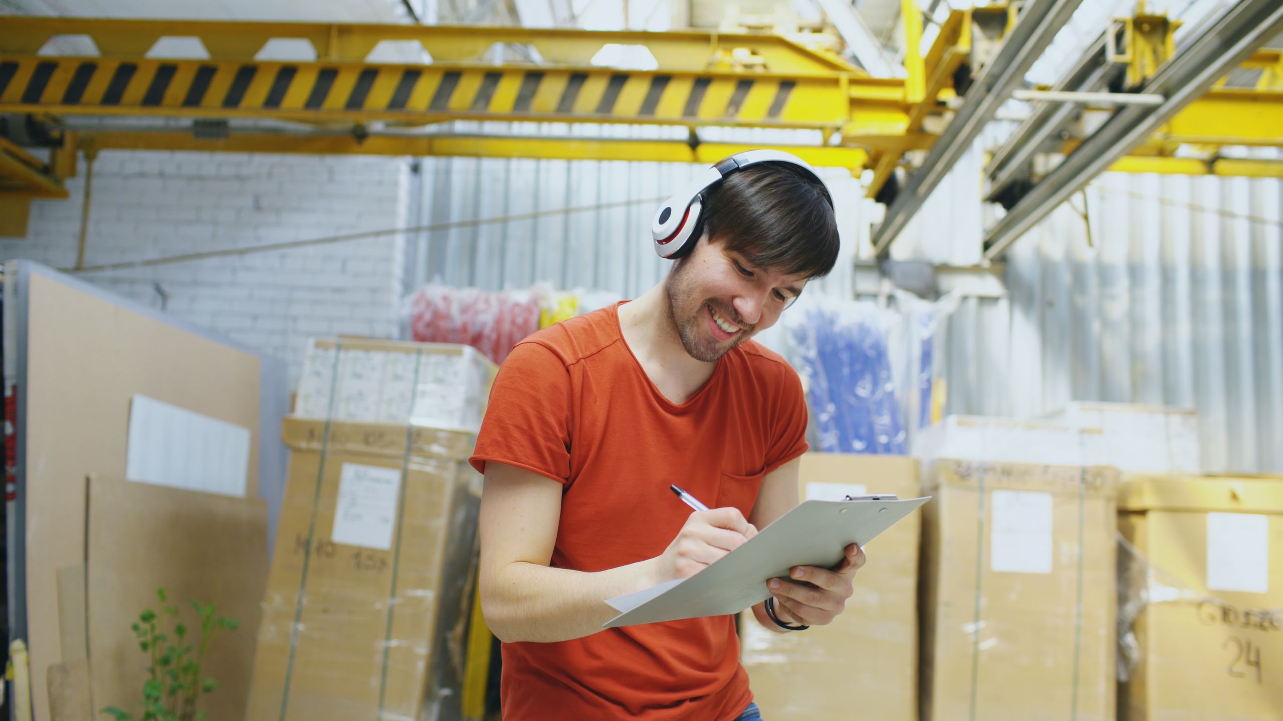 Warehouse worker writing on a clipboard