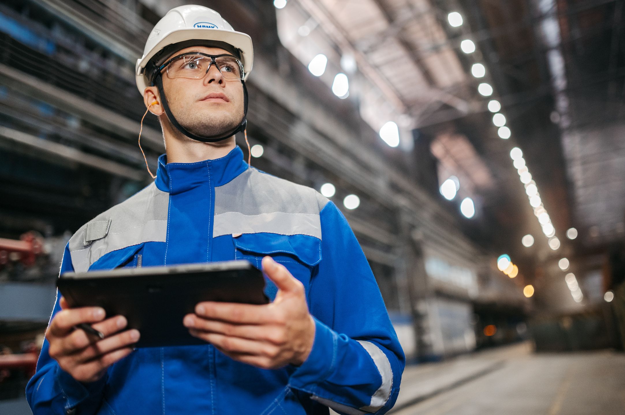Worker reviewing information on a tablet in an industrial facility