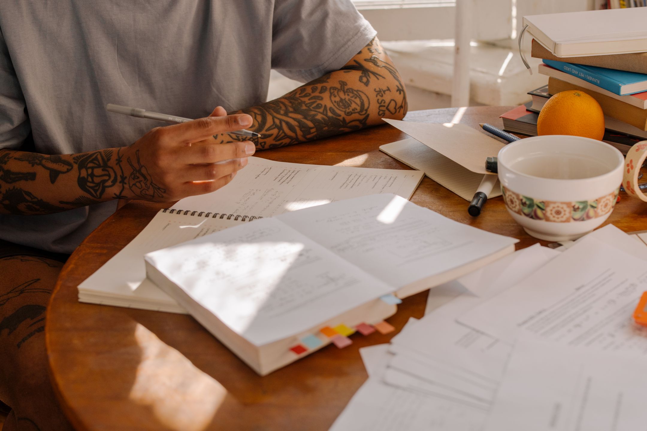 Person studying notes and materials at a desk