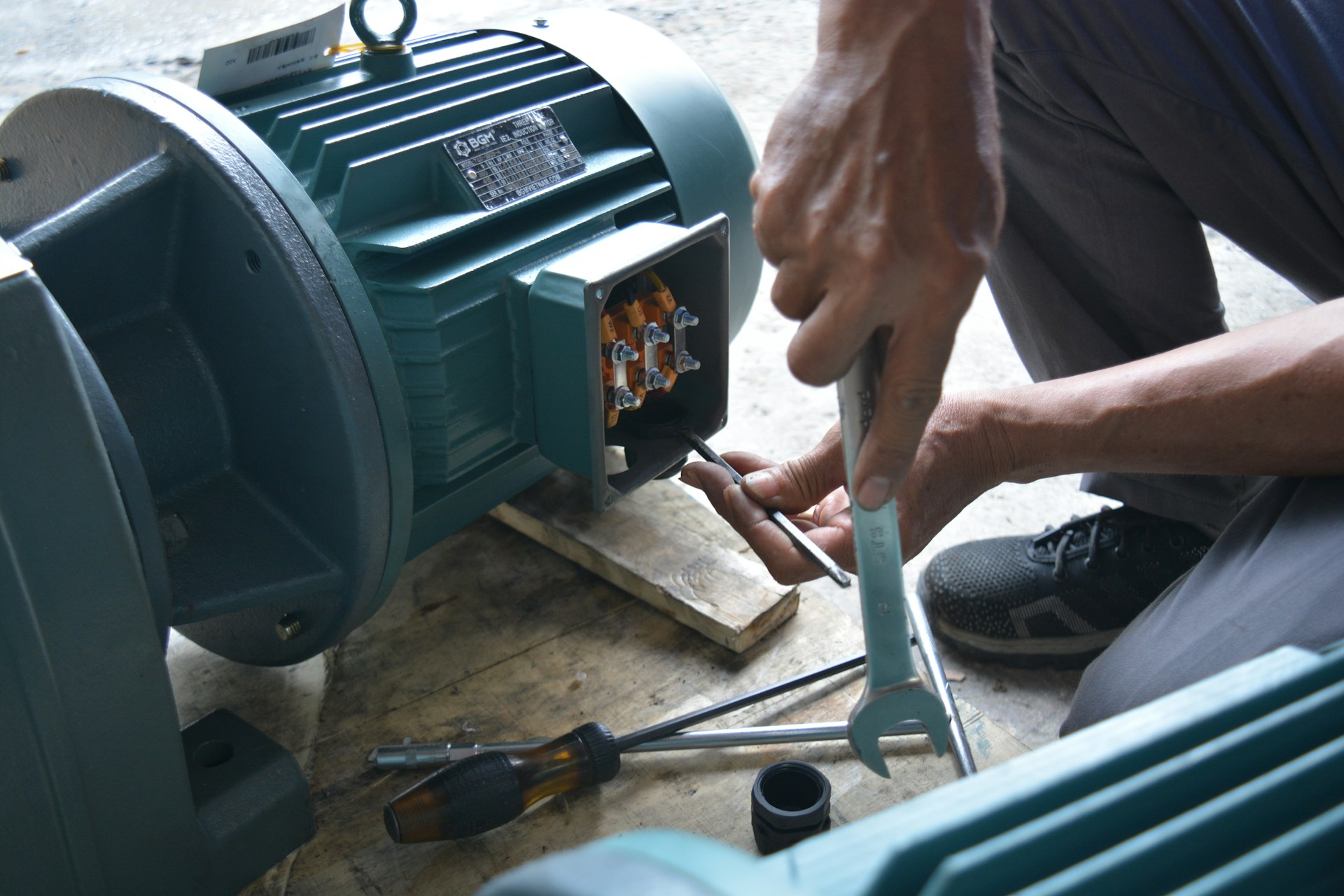 Maintenance technician examining a pump motor during a breakdown investigation