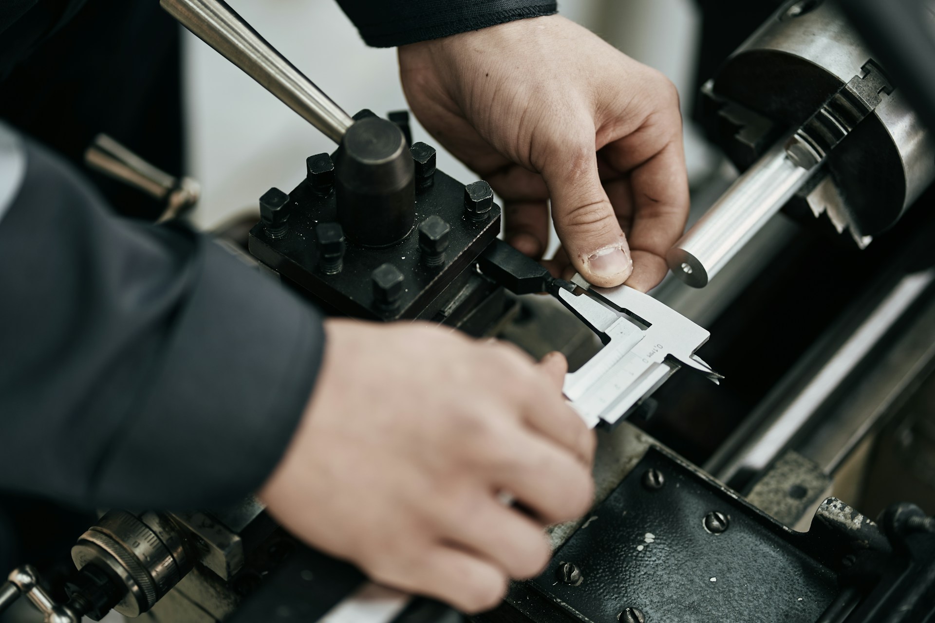 Hands using digital calipers to check part dimensions