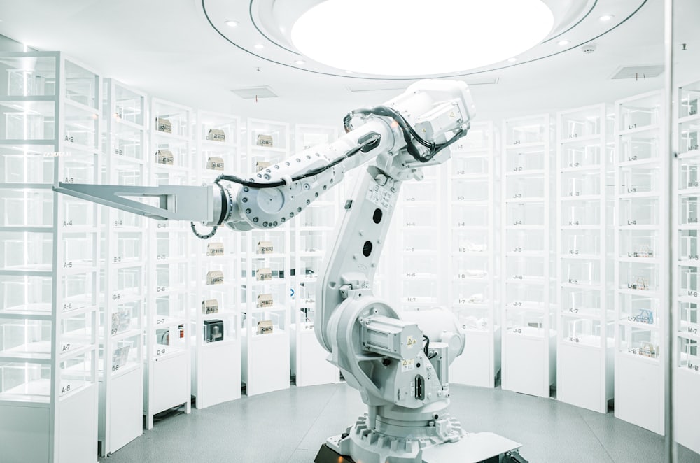 White robotic arm on display in a clean, modern automation showroom
