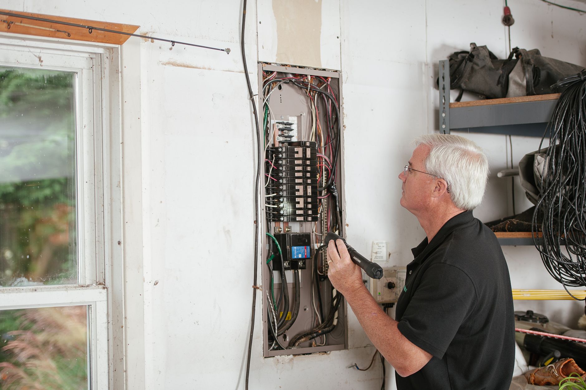 Electrician inspecting a circuit breaker panel