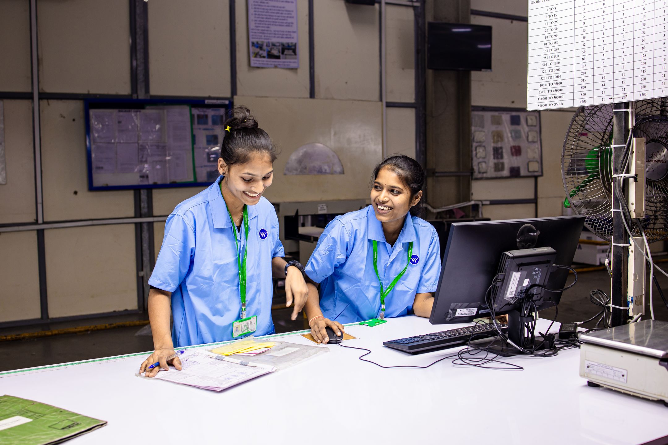 Workers discussing next steps at a workstation