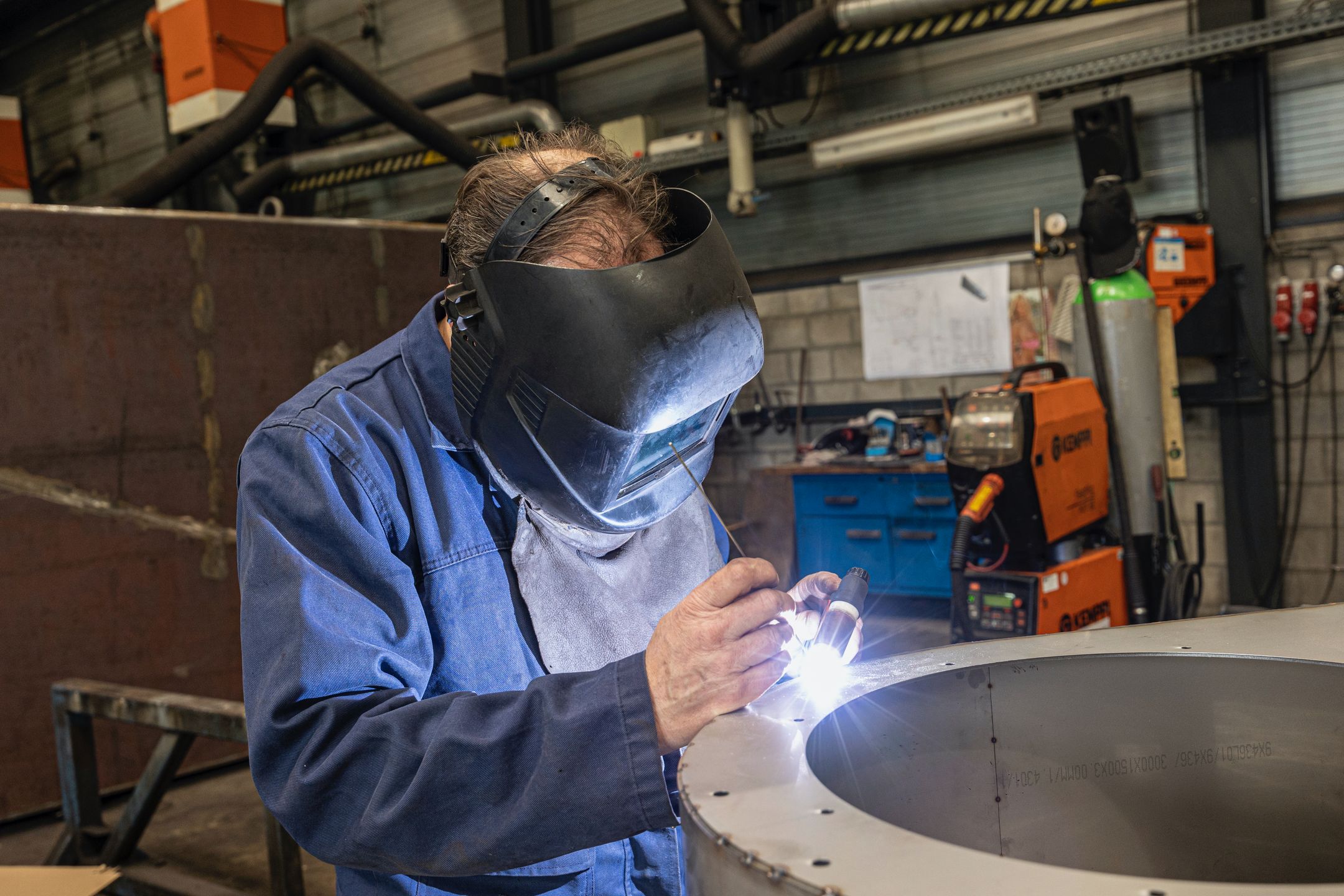 Welder working in a modern workshop with equipment