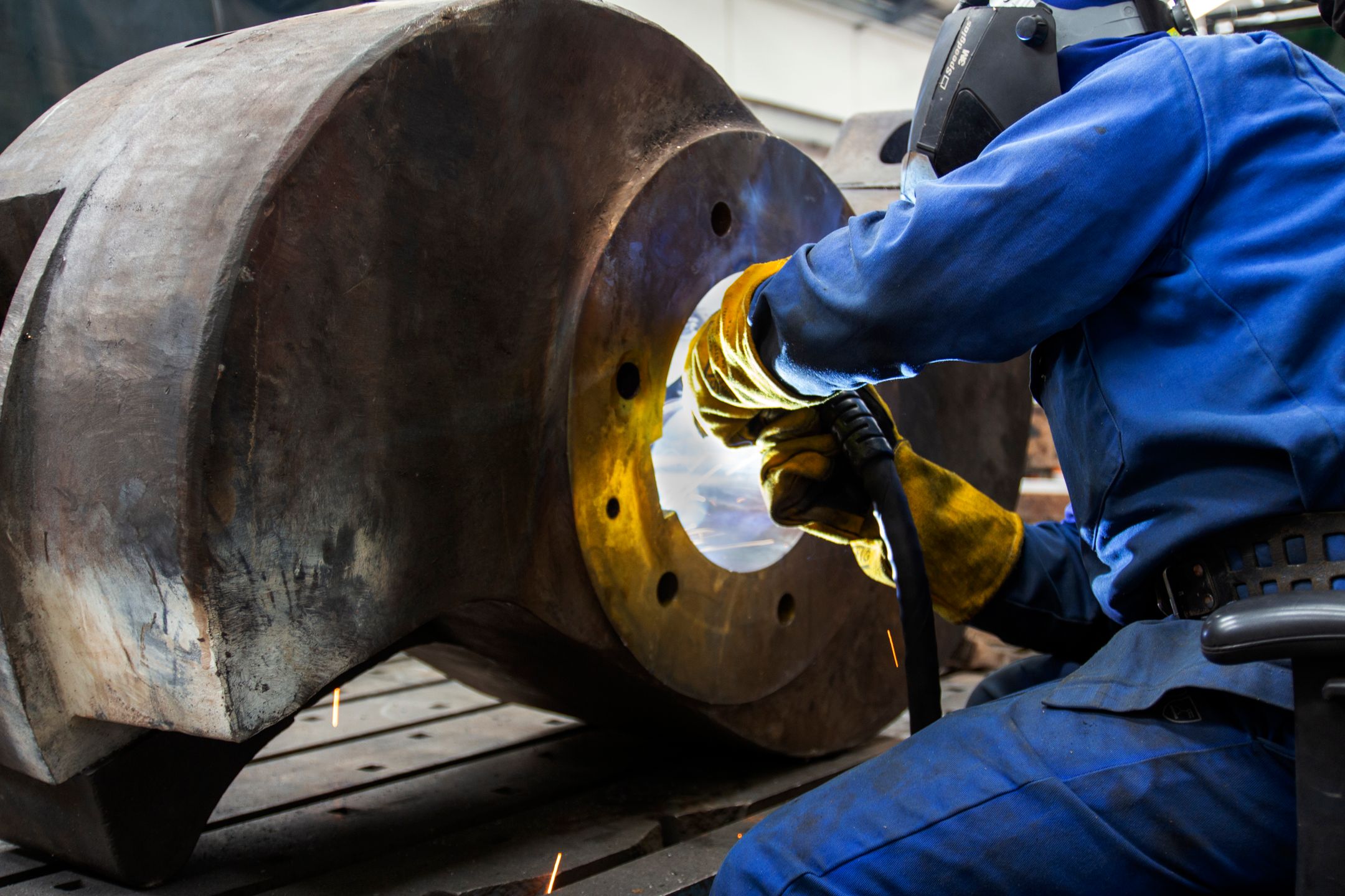 Welder operating on a large metal component
